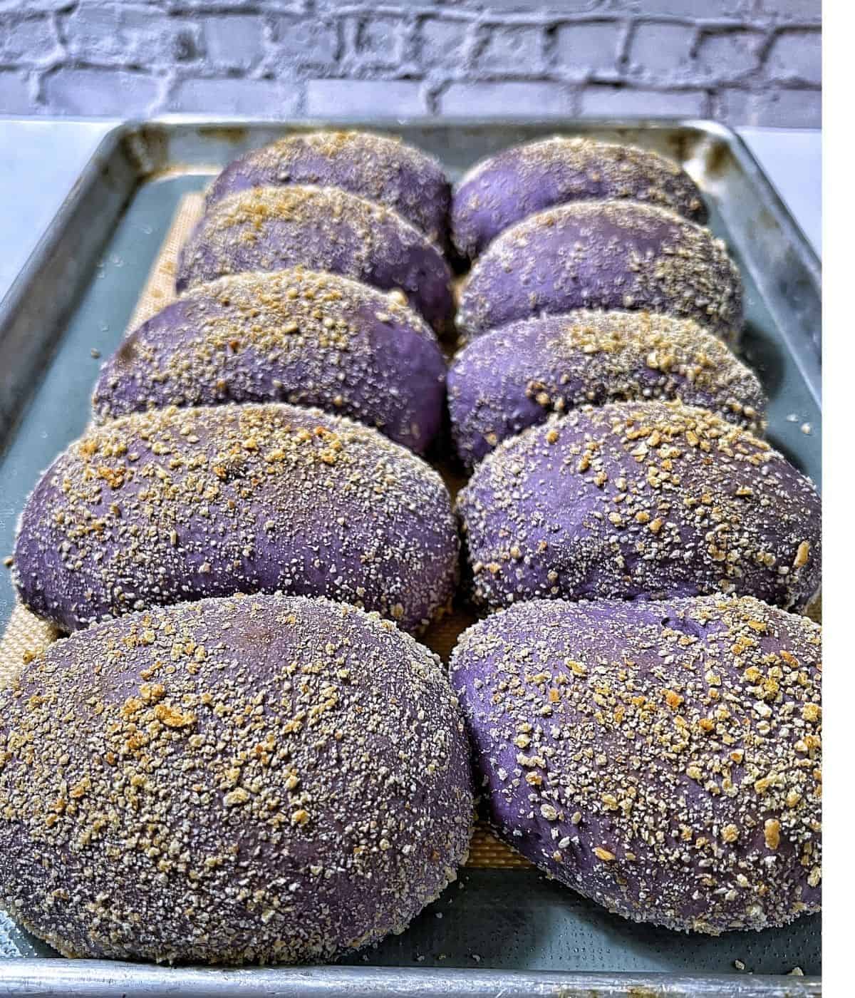 Baked ube pandesal on baking tray.