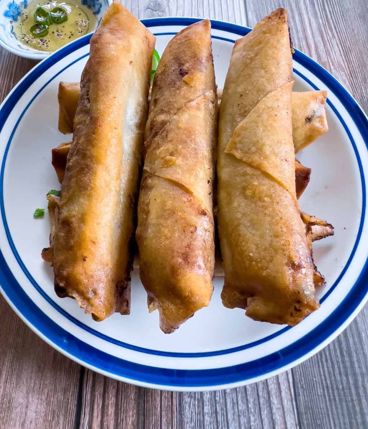 Crispy and golden brown beef lumpia on the plate.