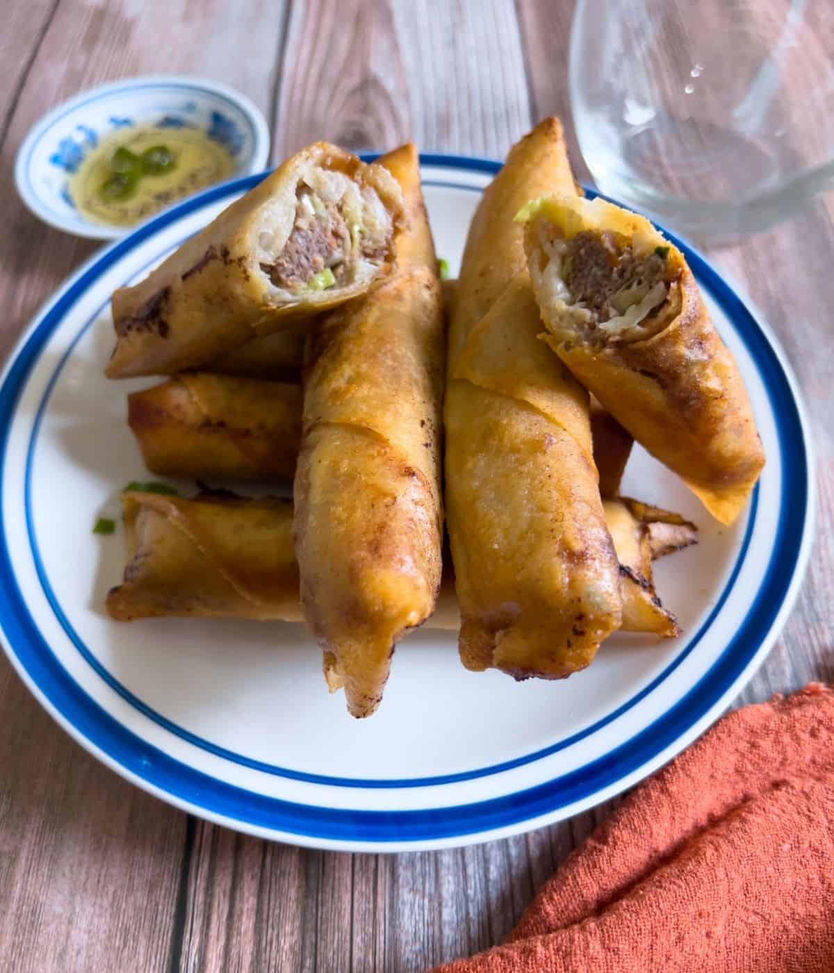 Beef lumpia with dipping sauce on the table.