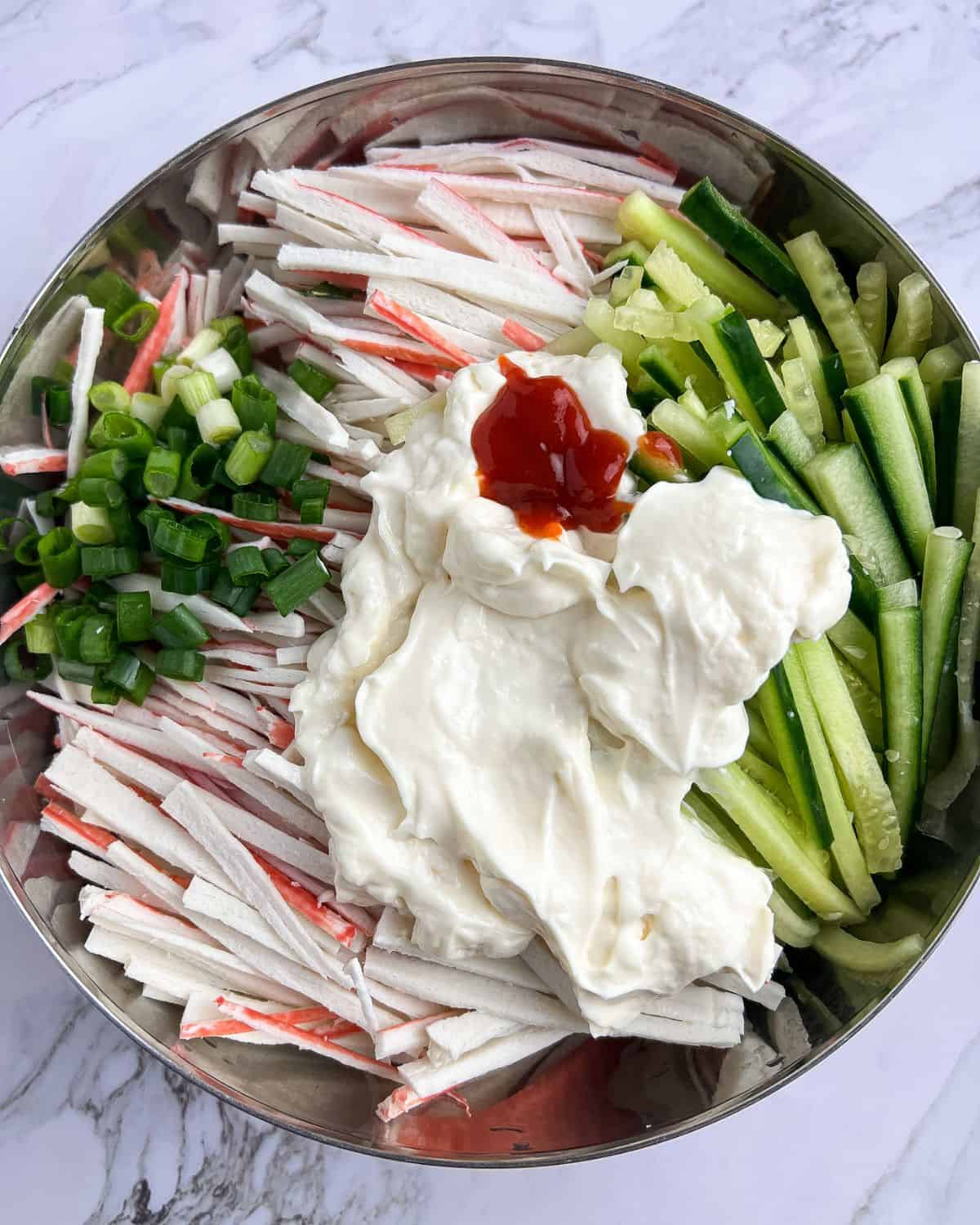 Combining all the ingredients for a kani salad.