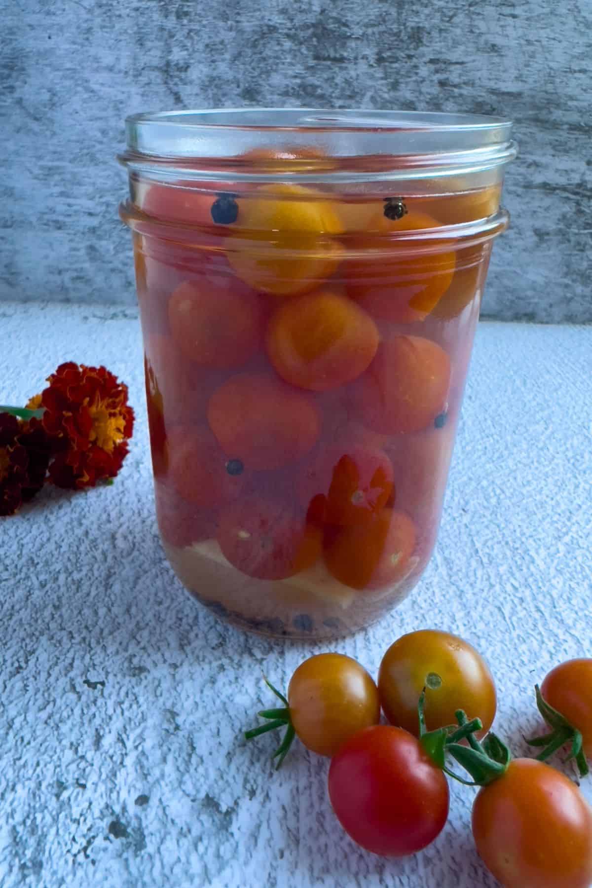 Pickled cherry tomatoes in a mason jar.