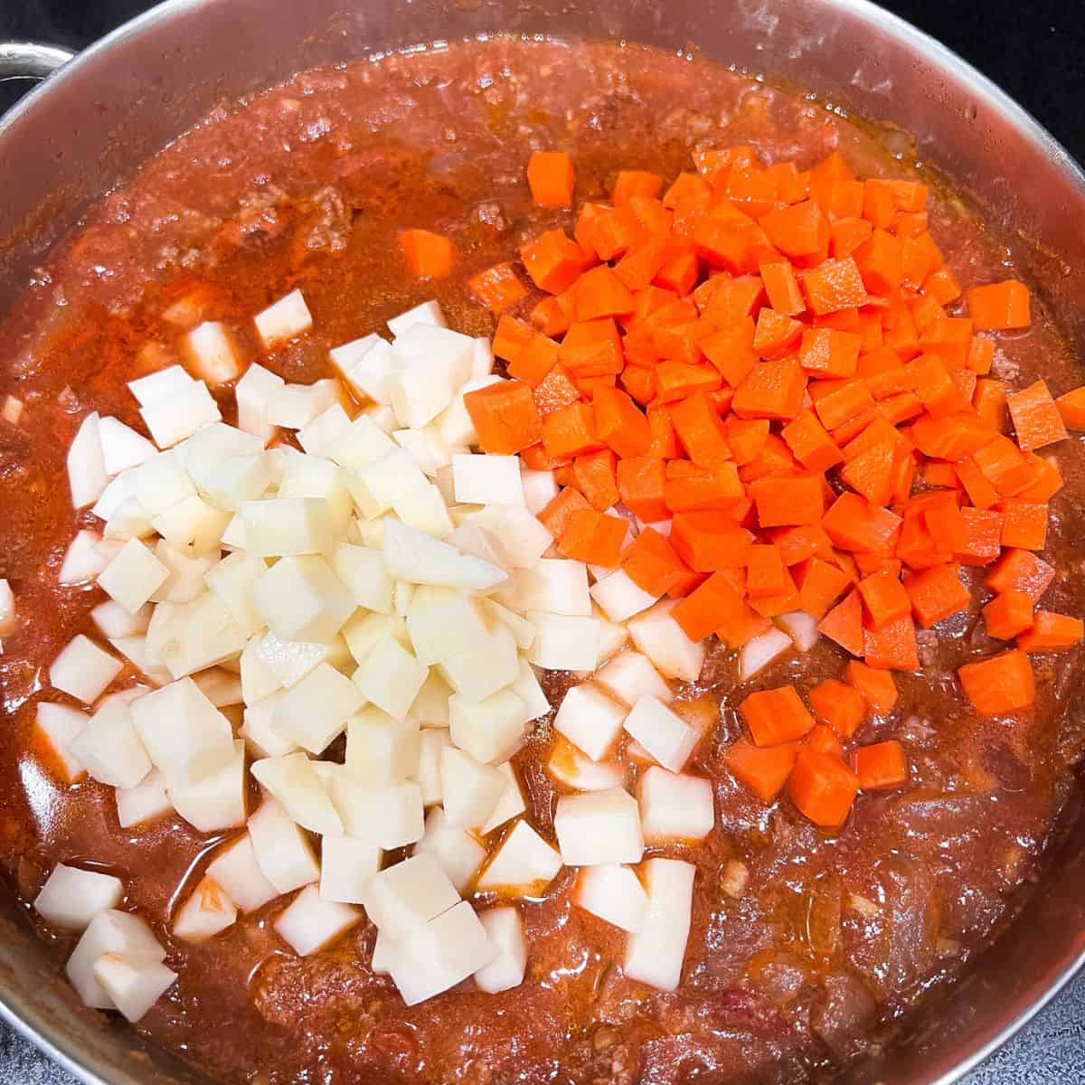 Adding carrots and potatoes.