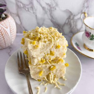 Finish dish of creamy maja blanca on a white plate with fork.