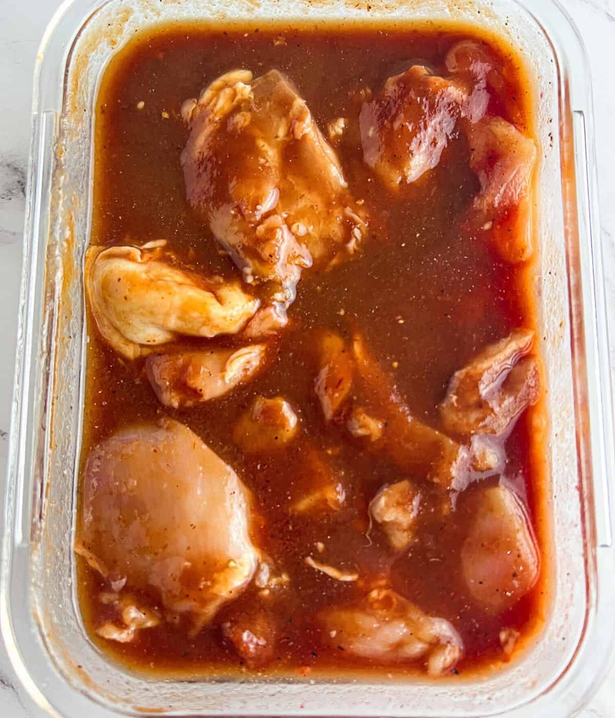 Marinating the chicken in the curing mixture.