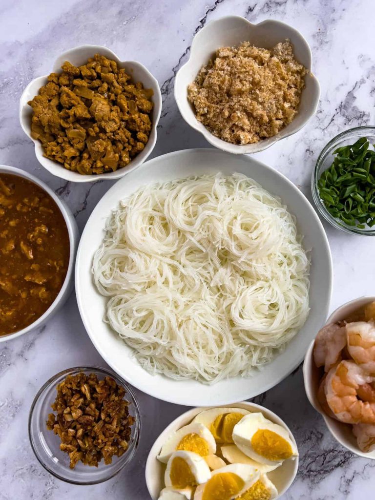 Pancit palabok jollibee copycat recipe with toppings in the sides.