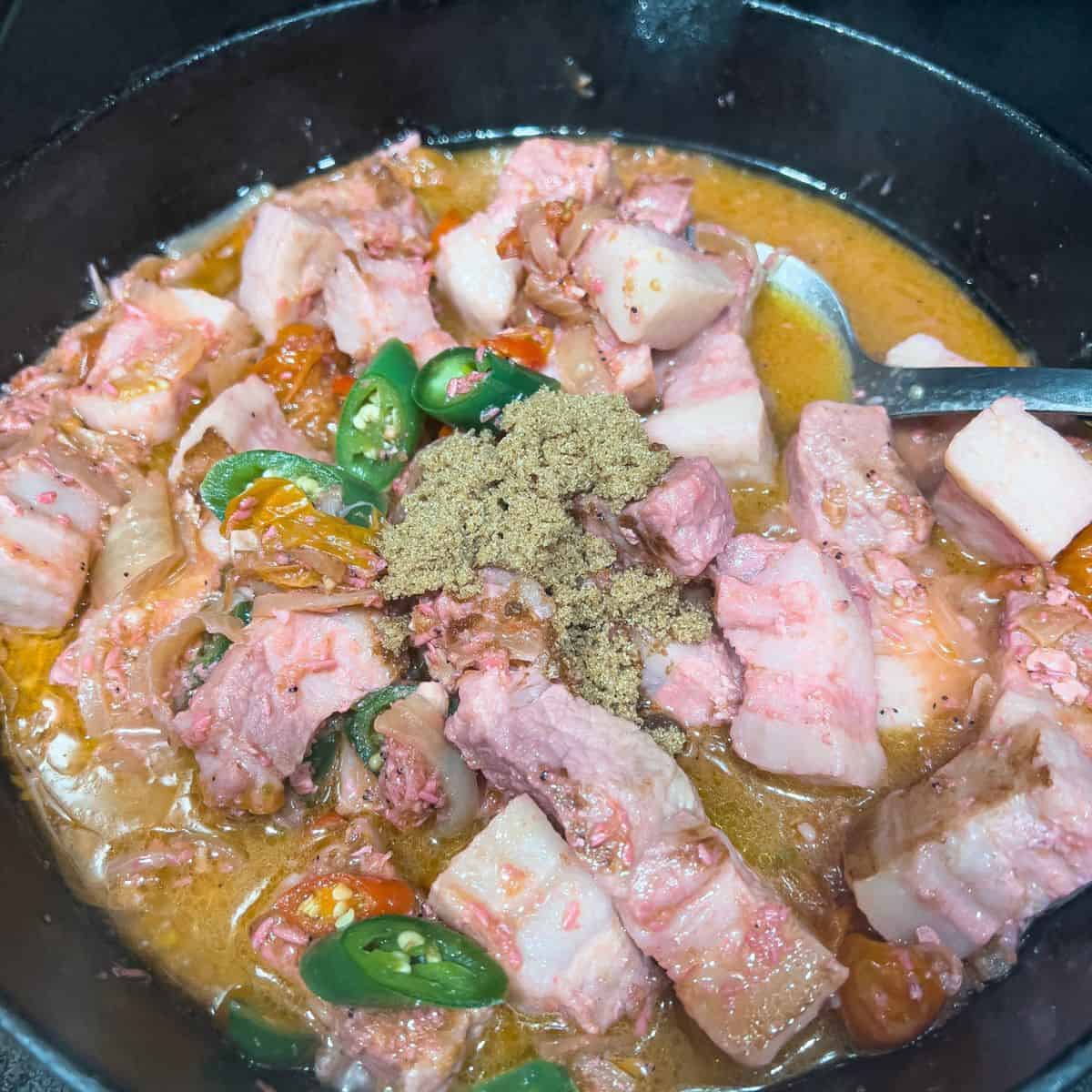 Adding jalapeno pepper, red chili, and brown sugar while the dish is almost done.