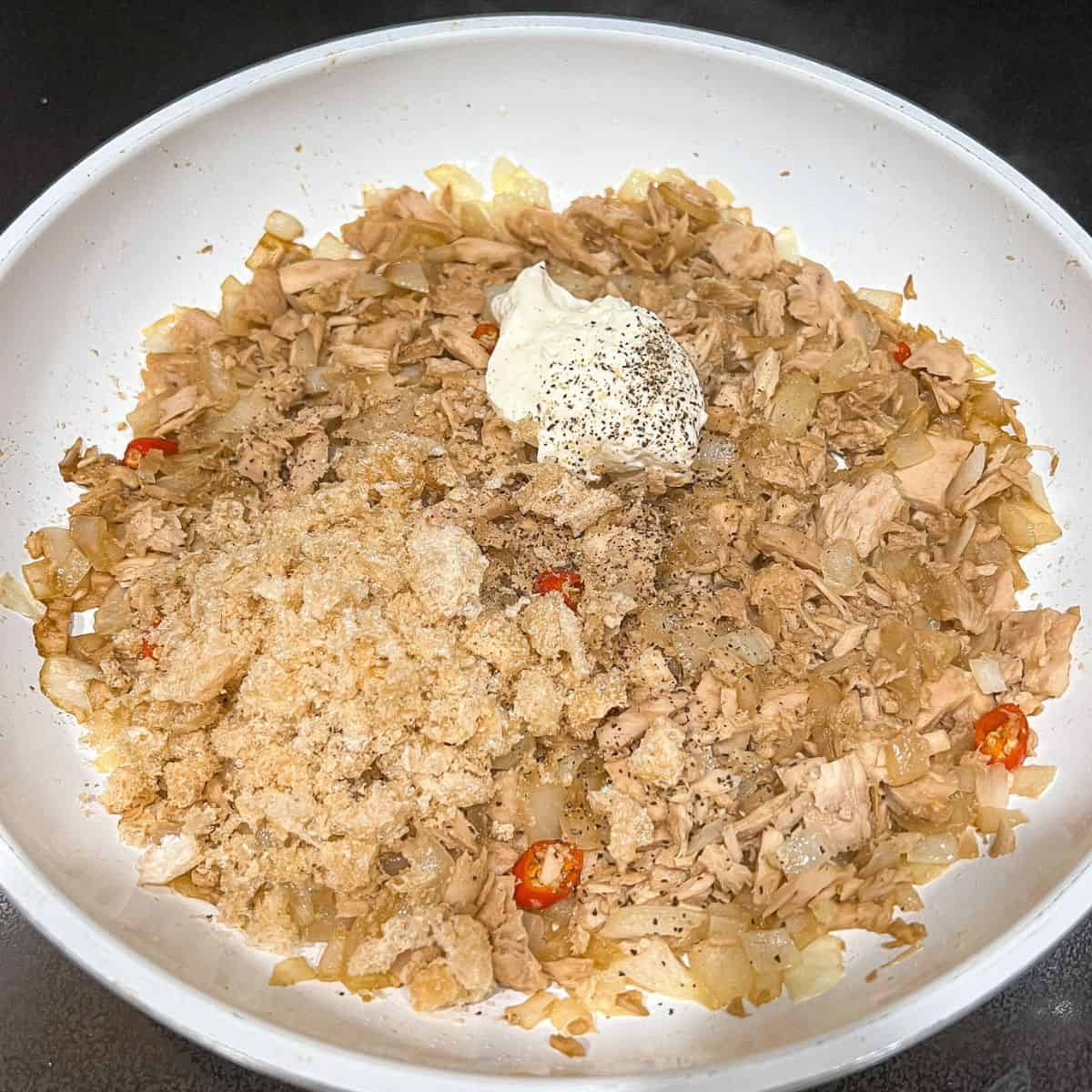 Adding mayonnaise, chicharron, and black pepper.