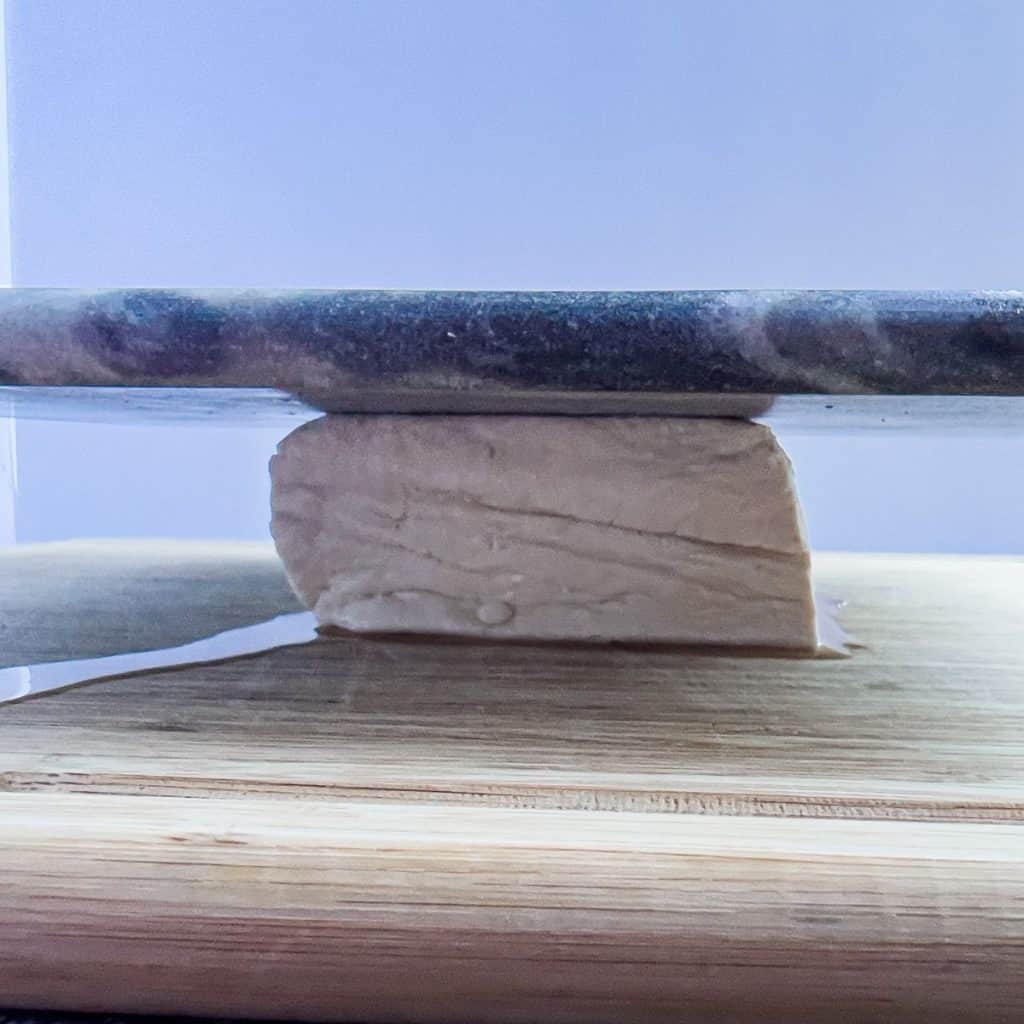 Pressing the tofu to get rid of excess water.