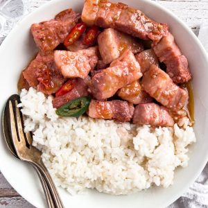 Finish dish of pork binagoongan with rice on a plate.